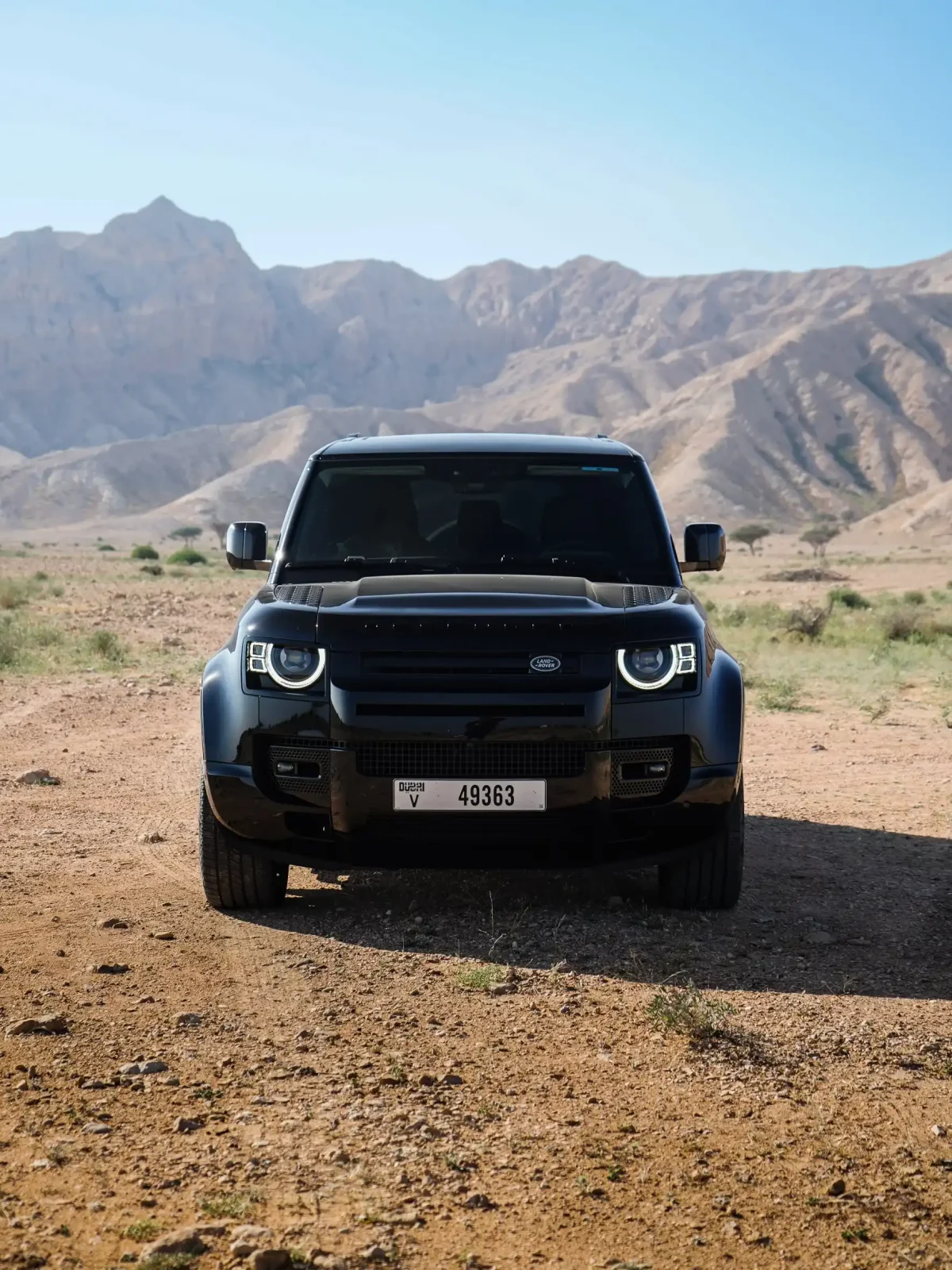 a picture of LAND ROVER DEFENDER 4 DOOR available for rental in dubai parked in sand dunes