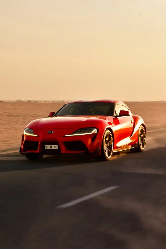 a picture of TOYOTA SUPRA GR available for rental in dubai with front view racing in dubai dessert