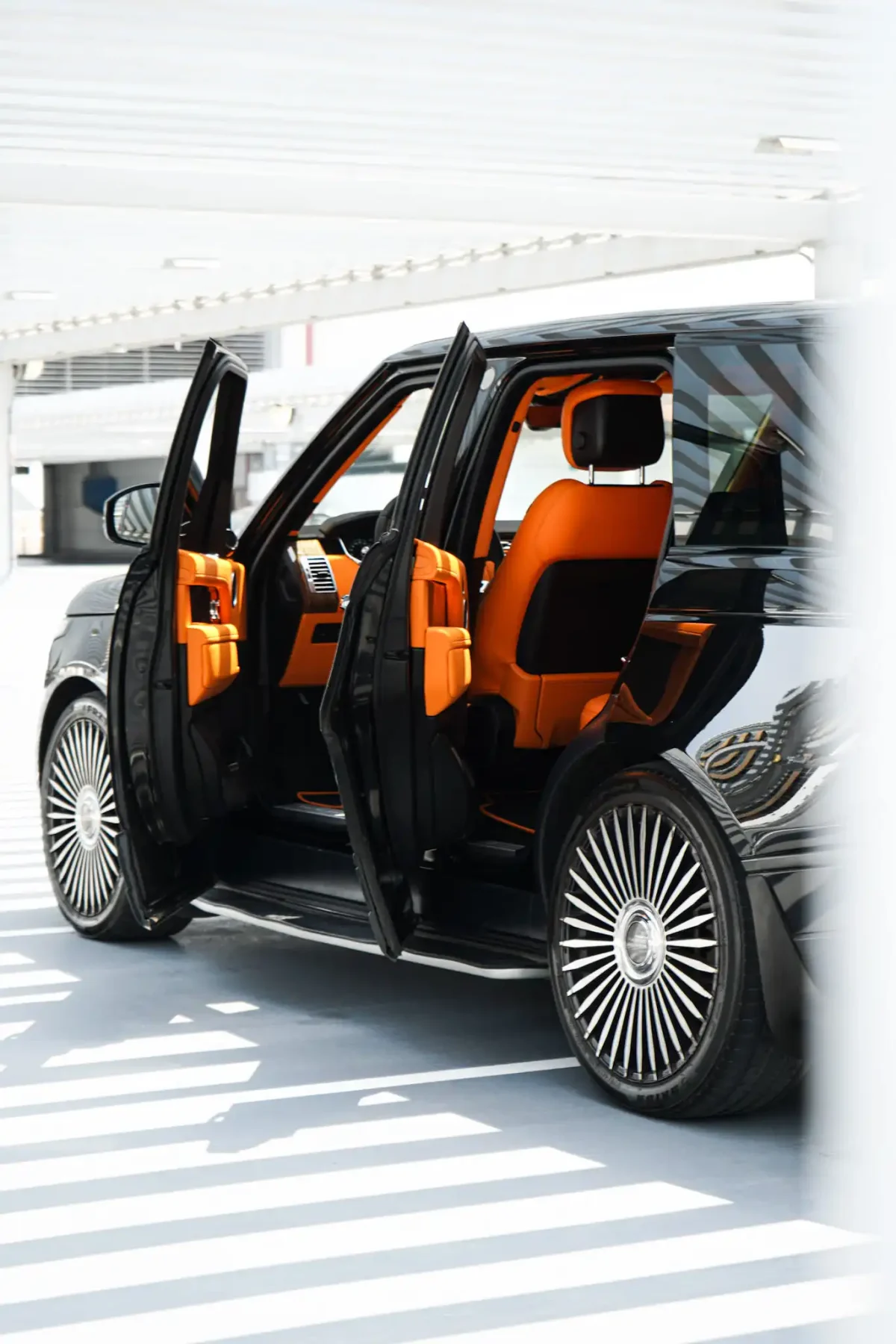 a picture of RANGE ROVER VOGUE available for rental in dubai with door opened and orange interior