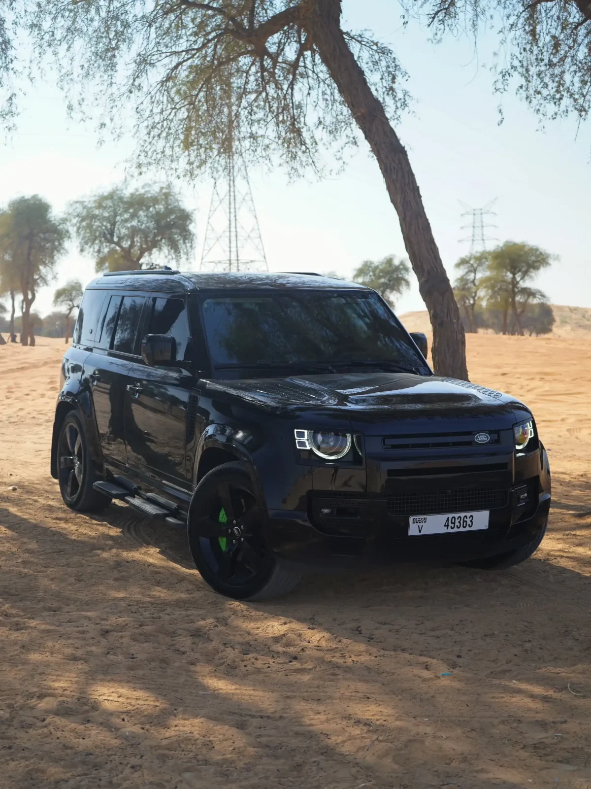 a picture of LAND ROVER DEFENDER 4 DOOR available for rental in dubai parked in dessert